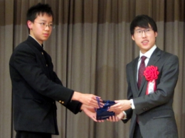 関西棋院の院生としてプロを目指している中学2年生の施毅龍君から記念品を受け取る井山棋聖